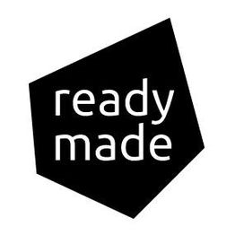 Schwarzes Fünfeck mit weißem Text "ready made" auf unregelmäßigem schwarzen Hintergrund.