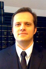 Eine Person im Anzug mit Büchern im Hintergrund.