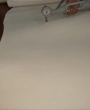 Papel blanco sobre una mesa de madera con un calibre medidor en la parte superior.