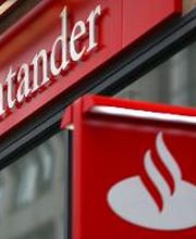 Logotipo vermelho do banco Santander em uma fachada de prédio cinza.