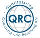 Logo des Qualitätsring Coaching und Beratung e.V. mit Globusgrafik im Hintergrund.