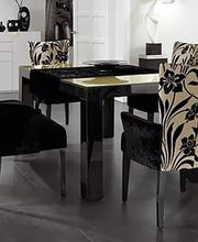 Esszimmer mit schwarzem Tisch und Stühlen mit floralem Muster in beige und schwarz.