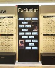 Wand met brillen in een winkelsectie voor vrouwen en exclusieve modellen.