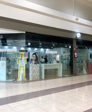 Una óptica en un centro comercial, con vitrinas y carteles en el exterior.