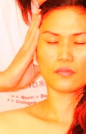 Frau genießt eine Kopfmassage mit geschlossenen Augen.