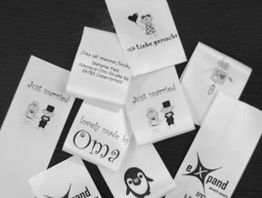 Verschiedene Etiketten mit Texten wie "Mit Liebe gemacht", "Just married" und Symbolen auf Papier.