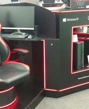 Postazione gaming Omen con sedia, tastiera e monitor in esposizione su pavimento grigio.