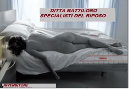 Donna sdraiata su un materasso in una stanza luminosa. Testo: "Ditta Battiloro Specialisti del Riposo".