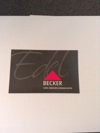 Visitenkarte mit Schriftzug "Edel", darunter "Becker, Ihre Immobilienmaklerin" auf schwarzem Hintergrund.