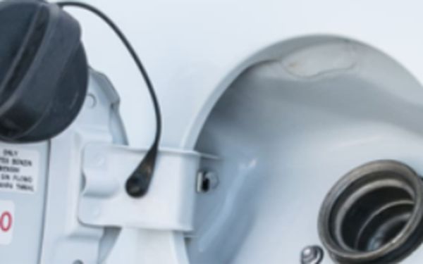 Ein weißes Auto in Nahaufnahme mit einem geöffneten Tankdeckel.