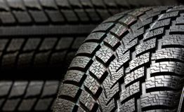 Close-up de pneus pretos com padrões de banda de rodagem visíveis.