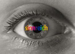 Nahaufnahme eines Auges mit Wort "sinnreich" in Regenbogenfarben auf der Iris.