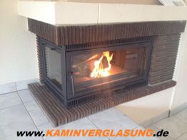 Kamin mit Glasscheibe und brennendem Feuer, Webseite www.KAMINVERGLASUNG.de am Boden.