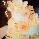 Elegant three-tier cake with peach and cream flowers.