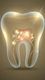 Ilustración de un diente transparente con luces brillantes y raíces luminosas en su interior.
