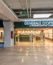Devanture d'une boutique Générale d'Optique dans un centre commercial avec des escaliers roulants.