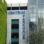 Gebäude mit Beschriftung "Centrum Parkhaus", grün bewachsen, daneben moderne Glasfassade.