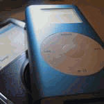 Zwei blaue tragbare Musikplayer liegen übereinander auf einem Tisch.