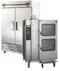 Commercial kitchen appliances: a large refrigerator next to a double-door oven on wheels.