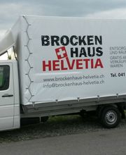Weißer Lieferwagen mit "Brockenhaus Helvetia"-Werbung geparkt auf einer Straße.