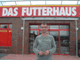Mann vor einem Geschäft mit der Aufschrift "Das Futterhaus" auf dem Schild über dem Eingang.