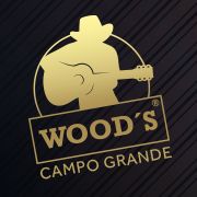 Silhueta de cowboy com violão e logotipo dourado: "Wood's Campo Grande". Fundo listrado escuro.