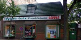 Gebäude mit einem Geschäft für Gartenbedarf namens Osdoba und einem grünen Dach.