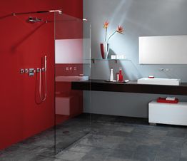 Modernes Bad mit roter Wand, großer Dusche, grauem Boden, Waschtisch und Dekoration.