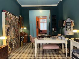 Ein stilvoller Raum mit Tisch, Stühlen, Regalen und geometrischem Bodenmuster.