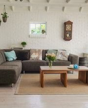 Sala de estar moderna con sofá marrón, mesa de madera y decoración sencilla.