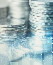 Münzstapel und Finanzdiagramme; Konzept für Wirtschaft und Wachstum.