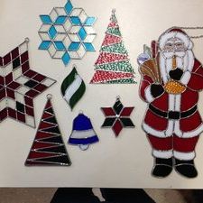 Stained glass shapes including stars, trees, a bell, and Santa on a white background.