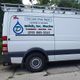 White plumbing company van parked with contact details on the side.