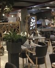 Ein stilvoll eingerichtetes Restaurant mit Holzdekor und gedeckten Tischen in gemütlicher Atmosphäre.