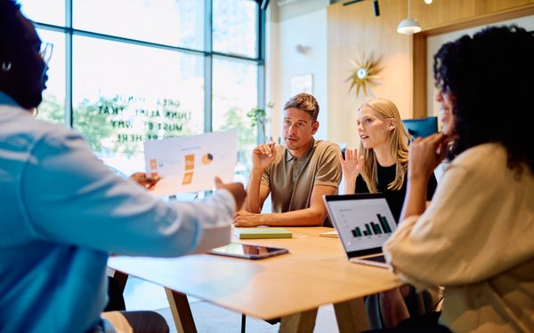 Team bespricht gemeinsam Geschäftsideen und Auswertungen bei einem Meeting zur Unternehmensgründung.
