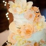 Elegant three-tier cake with peach and cream flowers.