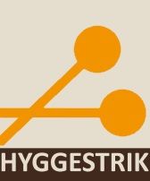 To orange strikkepinde og teksten "HYGGESTRIK" på beige baggrund.