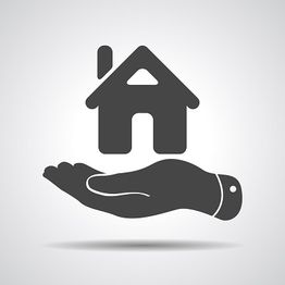 Hand holding a house icon, symbolizing real estate or home insurance.
