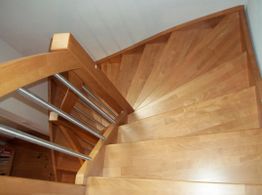 Holztreppe mit Metallgeländer von oben fotografiert.