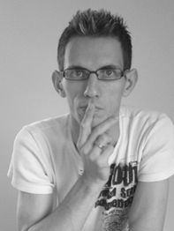 Mann mit Brille in Gedanken versunken, hält einen Finger an den Mund. Schwarz-weiß Bild.