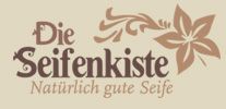 Logo mit Schriftzug: "Die Seifenkiste - Natürlich gute Seife" und floralen Verzierungen.