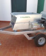 Macchinario metallico su ruote, posto su pavimento di cotto, con motore laterale.