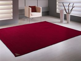 Moderner Raum mit rotem Teppich, weißem Sessel und Dekorationsvasen.