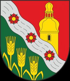 Wappen mit gelbem Turm, rotem Hintergrund, Kornähren und geschwungenem Streifen mit Blumen.