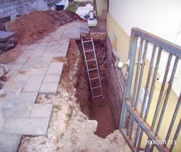 Grabenaushub für Isolierarbeiten an Kellerwand