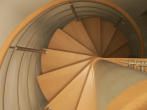 Holz-Wendeltreppe von oben fotografiert, spiralförmiges Design mit Metallgeländer.