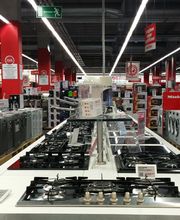 Negozio di elettrodomestici con lavatrici, piani cottura e altri apparecchi esposti.