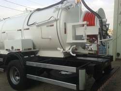 Caminhão tanque branco estacionado, usado para transporte de líquidos.