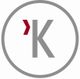 Grau-rotes "K" in Kreis auf weißem Hintergrund.