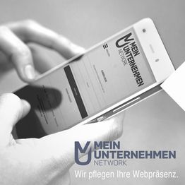 Smartphone mit "Mein Unternehmen Network"-Webseite, Slogan: "Wir pflegen Ihre Webpräsenz."